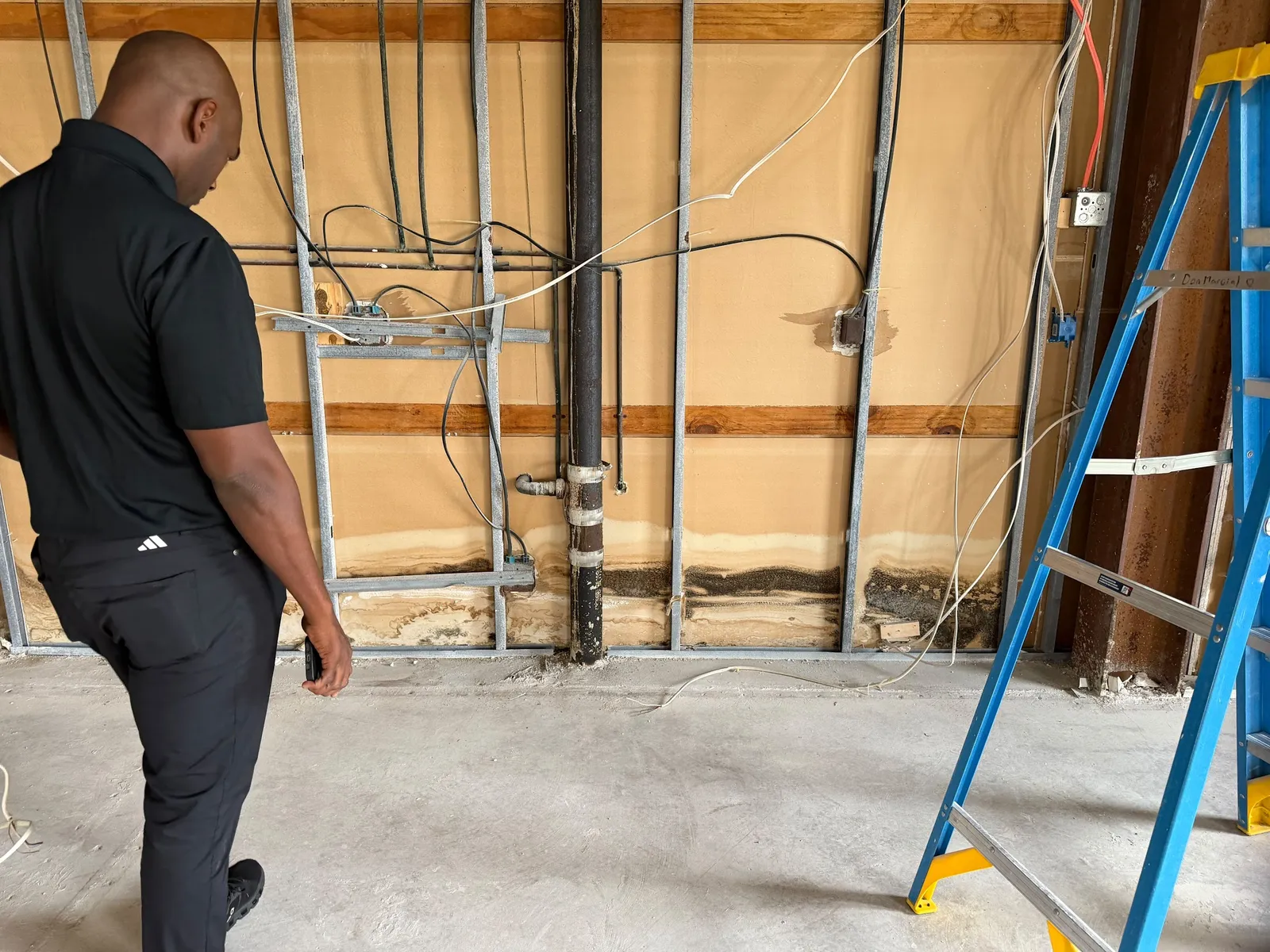 ITD Restoration technician assessing an opened wall during demolition