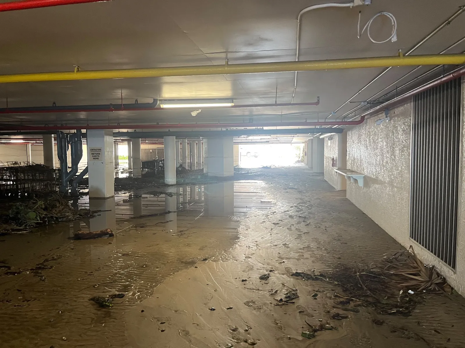 Flood damaged parking garage with mud and debris